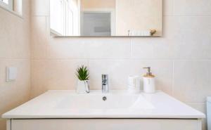 a bathroom with a white sink and a mirror at Marina Holiday House in Quarteira +22 photos