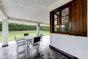 een patio met een tafel en stoelen en een raam bij Cottage Deluxe in Soiano del Lago