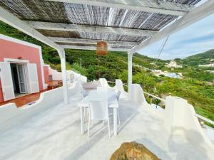einen weißen Tisch und Stühle auf dem Balkon eines Hauses in der Unterkunft Maridea - Vela in Ponza