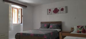 a bedroom with a bed and a window and a chair at Apartman Branka in Omiš