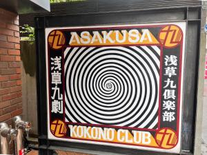 a sign with a large white spiral at Asakusa Kokono Club Hotel in Tokyo