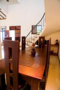 a dining room with a wooden table and a staircase at Villana Villa Bentota in Bentota