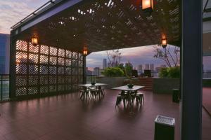 a rooftop patio with tables and chairs on a building at Citadines Gatot Subroto Jakarta in Jakarta
