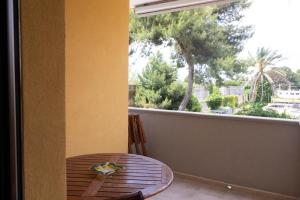 un tavolo e una sedia su un balcone con finestra di Casa via materdomini a Brindisi