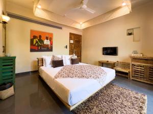1 dormitorio con 1 cama grande y TV de pantalla plana en 3102bce - A Vedic Resort en Vagator