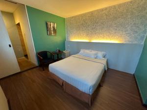 1 dormitorio con 1 cama y 1 silla en una habitación en Fajar Hotel, en Lahad Datu