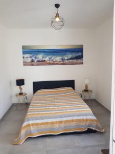 ein Schlafzimmer mit einem Bett und einem Wandgemälde in der Unterkunft Maisons T2 avec jardins privatifs - 10mn de la plage et 5mn du village - Casa di i trinelli in Vescovato