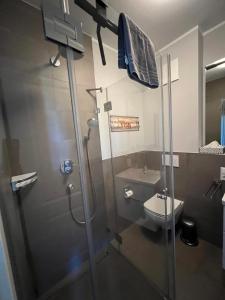 La salle de bains est pourvue d'une douche et d'un lavabo. dans l'établissement Strandvogt - wunderschöne Ferienwohnung mit Parkettboden und Sonnenbalkon, à Wangerooge