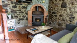 uma sala de estar com uma lareira de pedra e uma mesa em La Seronda de Villaorille - Las Casas del Oso 