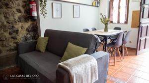 uma sala de estar com um sofá e uma mesa em La Seronda de Villaorille - Las Casas del Oso 