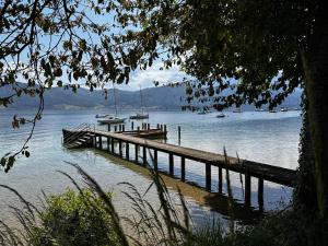 a dock on a lake with boats in the water at Lexenhof in Nussdorf am Attersee