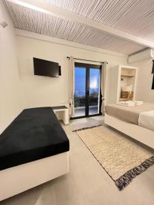 a white bedroom with a bed and a tv at Vie rêvée luxury suites in Ganema