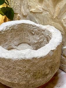 a stone bowl sitting next to a rock wall at Arcos de Medina - Apartamentos premium in Córdoba