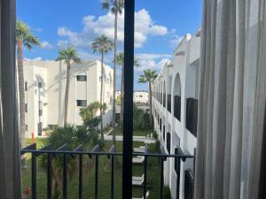 een balkon met uitzicht op een gebouw met palmbomen bij Les Orangers Garden Villas and Bungalows Ultra All inclusive in Hammamet