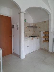 a kitchen with white cabinets and a pillar in a room at Bellavista in Dolceacqua