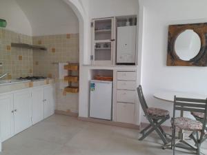 a kitchen with white cabinets and a table and chairs at Bellavista in Dolceacqua