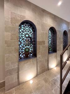 un mur en pierre avec deux fenêtres et un escalier dans l'établissement Arcos de Medina - Apartamentos premium, à Cordoue