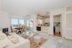 Apartment, close to the beach and sea views, in Marbella في مربلة: غرفة معيشة مع أريكة بيضاء وطاولة
