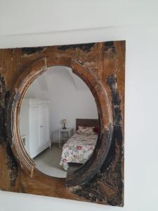 a mirror on a wall with a bed in a room at Bellavista in Dolceacqua