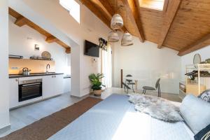維亞格蘭德的住宿－Baglio Delle Terre Nere - Affitti Brevi Italia，厨房以及带床和桌子的客厅。