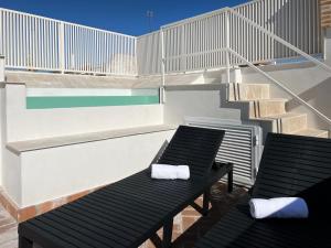 un balcón con 2 sillas y una piscina en Arcos de Medina - Apartamentos premium en Córdoba