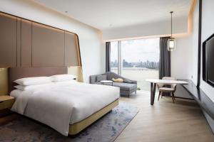 a bedroom with a bed and a table and a chair at Renaissance Zhuhai Hotel in Zhuhai