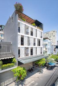 um edifício branco com plantas na lateral em Carol Homestay & Apartment Đà Nẵng 4 em Da Nang