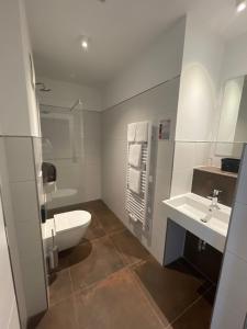 een witte badkamer met een toilet en een wastafel bij Stahltower in Friesoythe