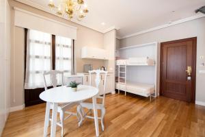 a small room with a table and chairs and a bunk bed at Hotel Infanta Isabel by Recordis Hotels in Segovia