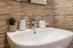 a white bathroom sink with two towels on it at Lumen House in Sassari