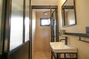 een badkamer met een wastafel, een spiegel en een douche bij Onos - 2 bedroom 2 bathroom penthouse with terrace in Old Town in Kalamata