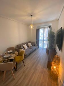 uma sala de estar com um sofá e uma mesa em " El Paraguas del Antiguo " Parking privado em Oviedo