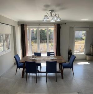 una sala da pranzo con tavolo in legno e sedie blu di Faidra's House a Città di Lefkada