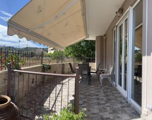 balcone con ombrellone, tavolo e sedie di Faidra's House a Città di Lefkada