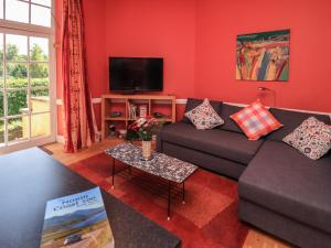 a living room with a couch and a tv at East Wing in Strathpeffer