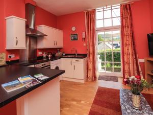 a kitchen with red walls and a large window at East Wing in Strathpeffer