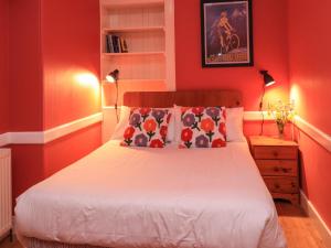 1 dormitorio con 1 cama con paredes rojas en East Wing, en Strathpeffer