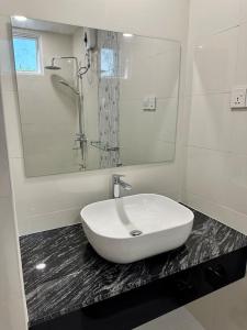 W łazience znajduje się biała umywalka i lustro. w obiekcie EQUATOR RETREAT w mieście Fuvahmulah