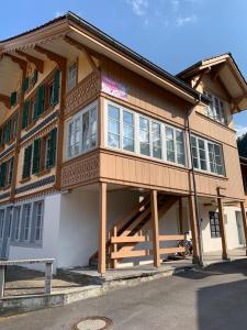 a large wooden building with a balcony on a street at Family Home - 30 in Wilderswil