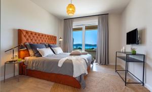 1 dormitorio con cama y ventana grande en Luxury villa Adris with heated pool, Gym, sauna - Split, en Kaštela