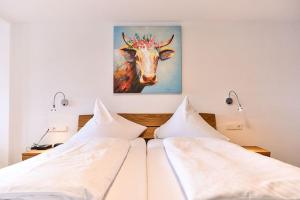 - une chambre avec deux lits et une peinture d'une vache dans l'établissement Hotel Hirschen, à Schluchsee