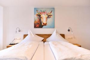 1 dormitorio con 2 camas y una pintura de una vaca en Hotel Hirschen, en Schluchsee