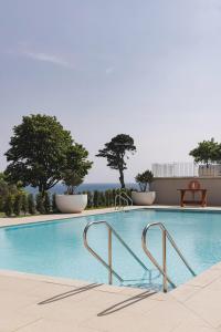 uma grande piscina com árvores ao fundo em Fowey Hall Hotel em Fowey