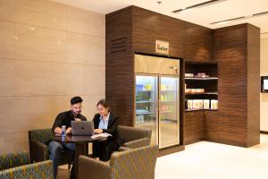 due persone sedute a un tavolo con un portatile di Fairfield by Marriott Agra ad Agra