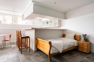 um quarto com uma cama, uma mesa e uma cadeira em Lägenhet i ett hus egen ingång em Sundbyberg