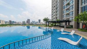 a large swimming pool with white chairs next to a building at Vinhomes Skylake Luxury Apartment 3 Br in Hanoi