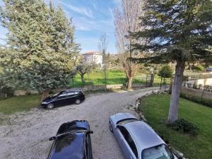 two cars parked on a gravel road next to a tree at La Luna's Home in Lanciano