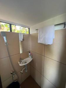 uma pequena casa de banho com um lavatório e uma janela em Casita Greens A-frame Hut em Kondotti