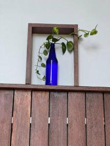 uma garrafa azul sentada em cima de uma cerca de madeira em Casita Greens A-frame Hut em Kondotti