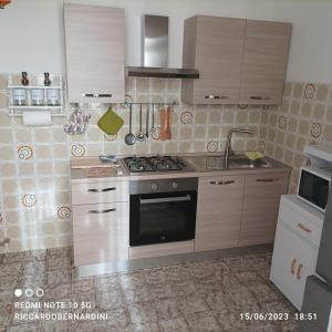 a kitchen with wooden cabinets and a stove top oven at DESTINAZIONE PARADISO in Piombino